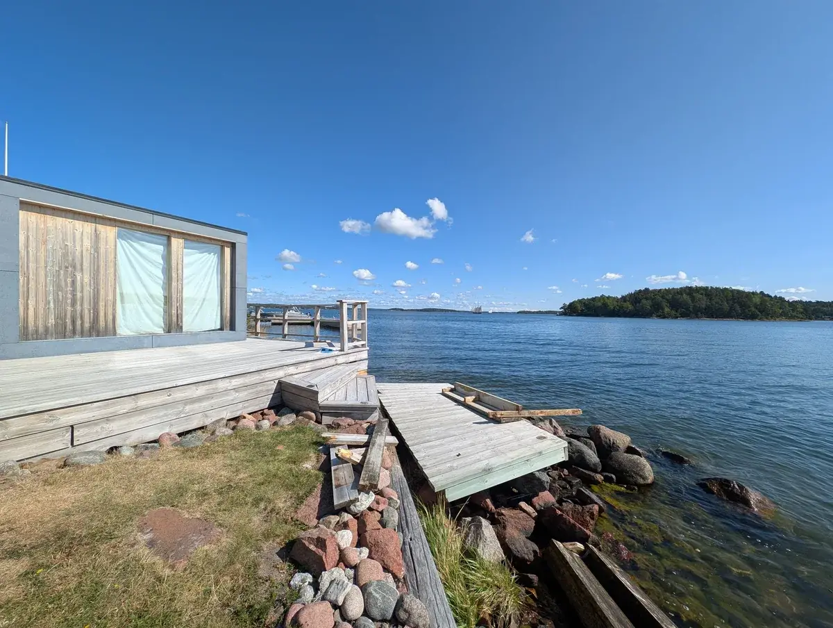 Träbyggnad och trädäck vid vattnet, fotograferat vid ett besiktningsuppdrag