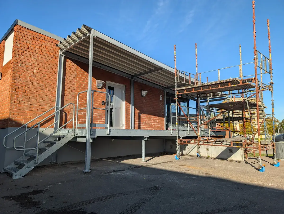 Ombyggnad med entrékonstruktion och byggställning vid ett tegelhus